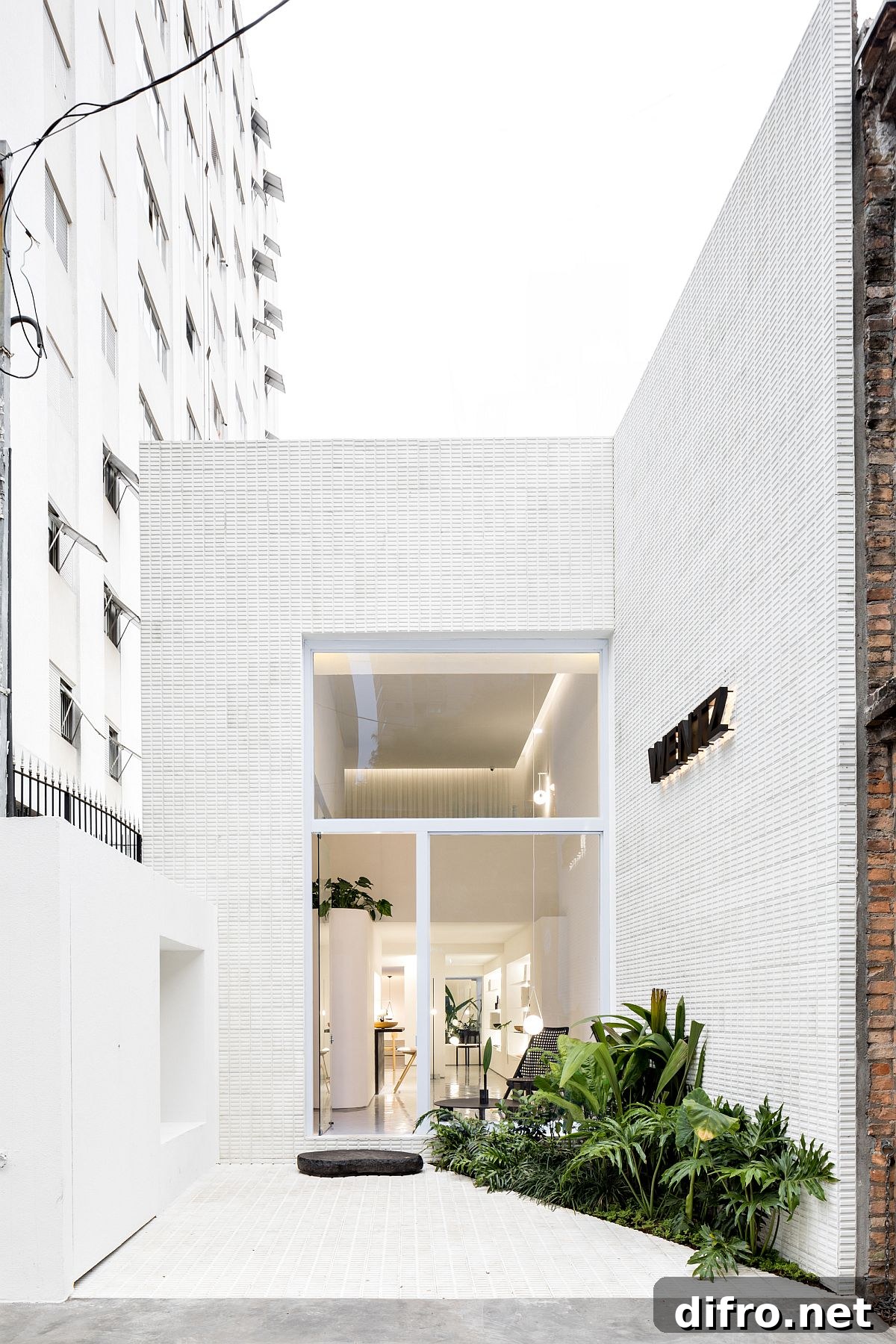 Protected and curated entrance of the store with its name and a monochromatic backdrop