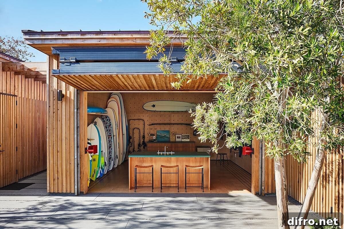 Customized surfboard storage unit at the entrance of the house acts as a windbreaker