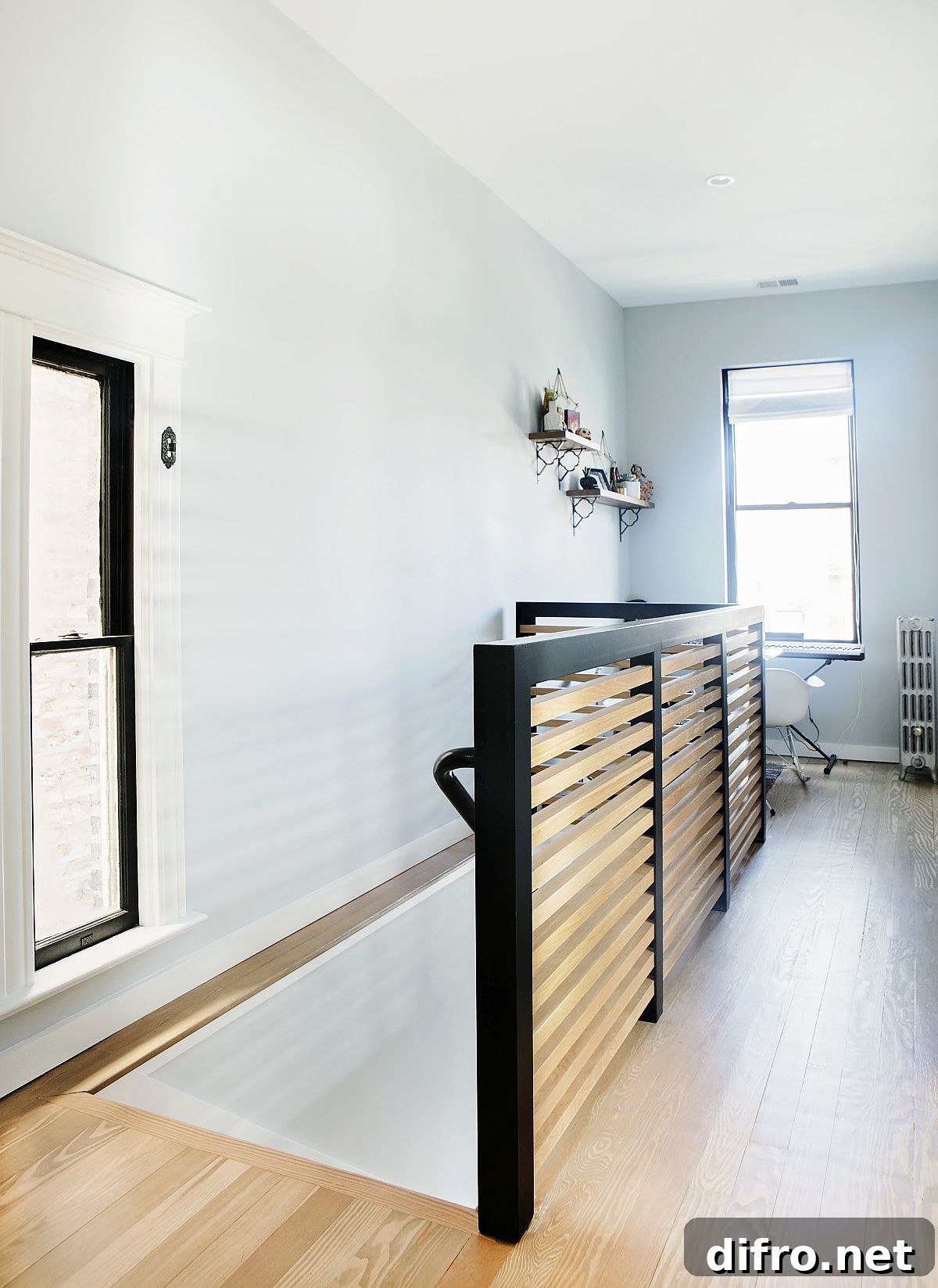 Wooden railing for the staircase with dark metallic bars on the edge