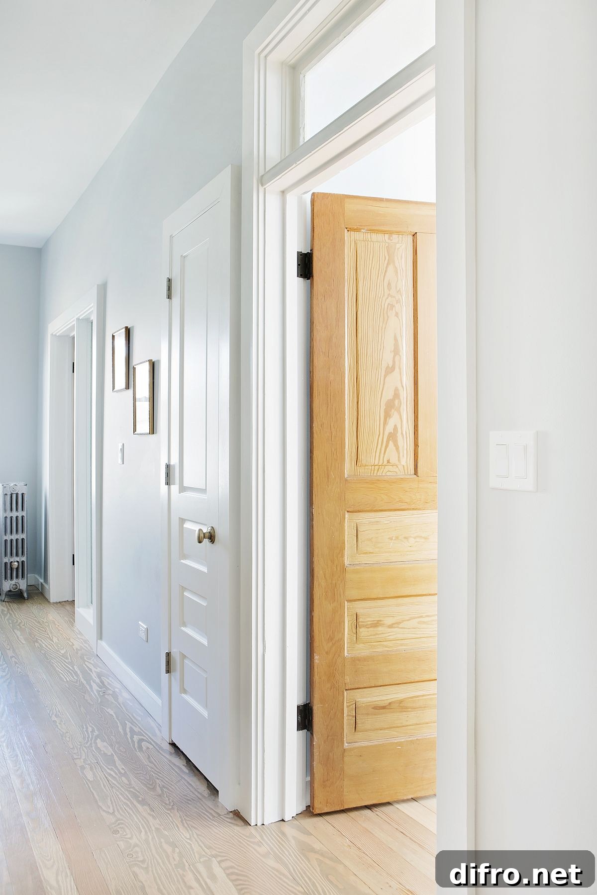 Large hallway of the home in white with ample natural light and wood walls for the room