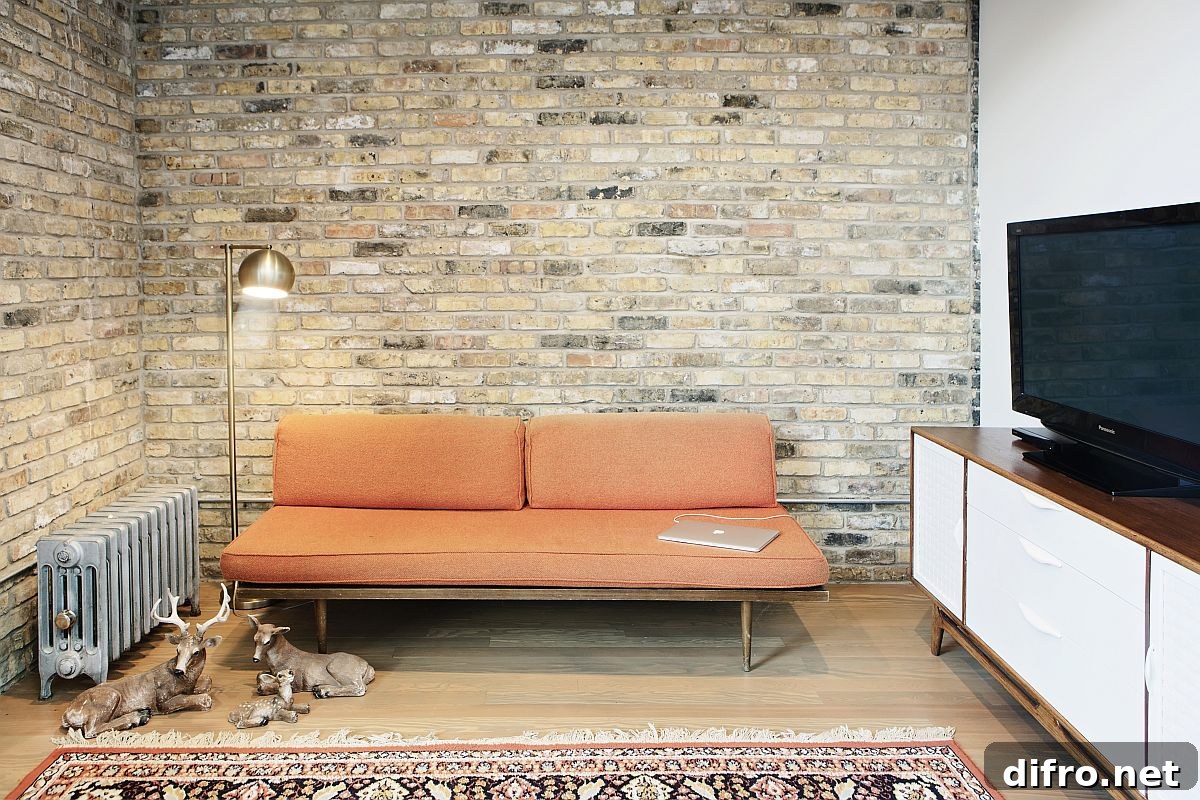 Small, upper level sitting space and living area of the home with an exposed brick wall
