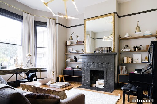 a brick fireplace painted black with mirror on mantel