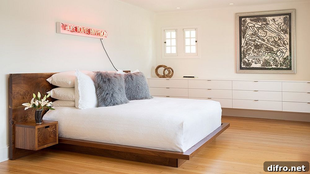 Contemporary white bedroom with a neon sign above the headboard