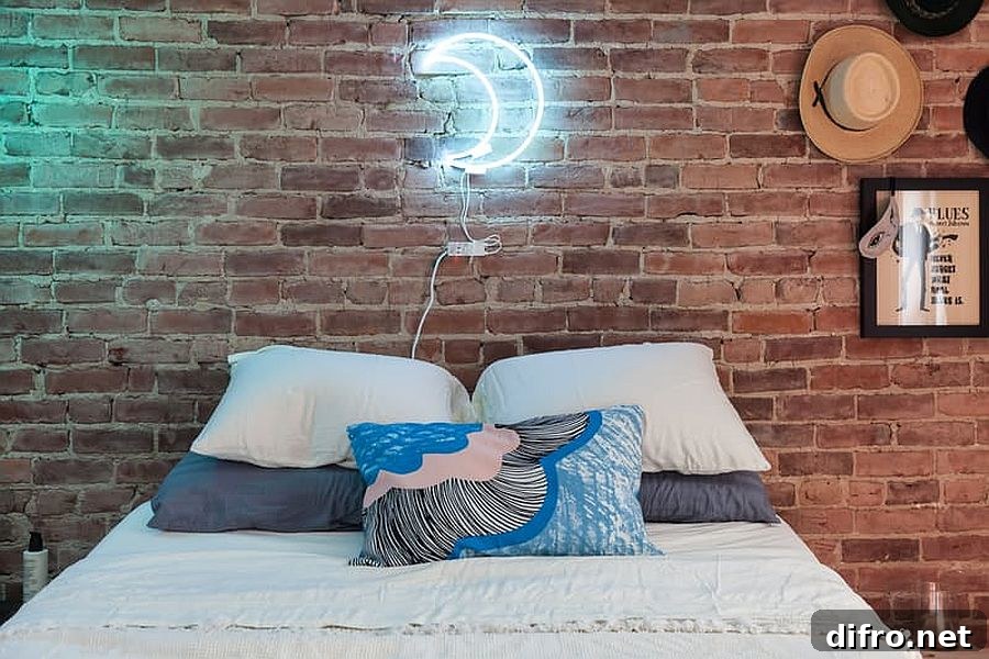 Industrial bedroom with brick wall and moon-shaped neon light