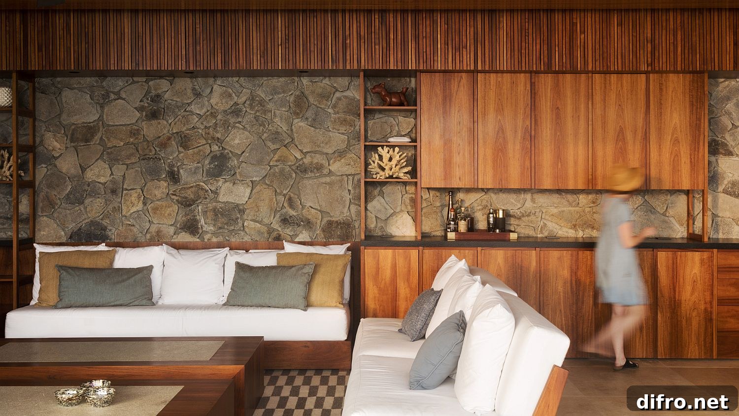 Stone and wood open living area flowing into a wooden deck with ocean views