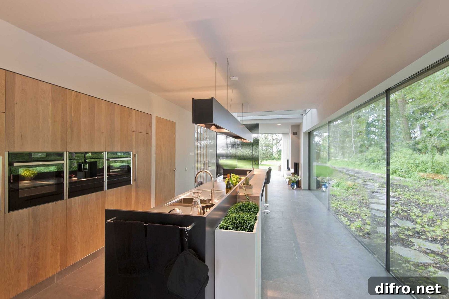 Kitchen with floor-to-ceiling glass windows offering panoramic forest views
