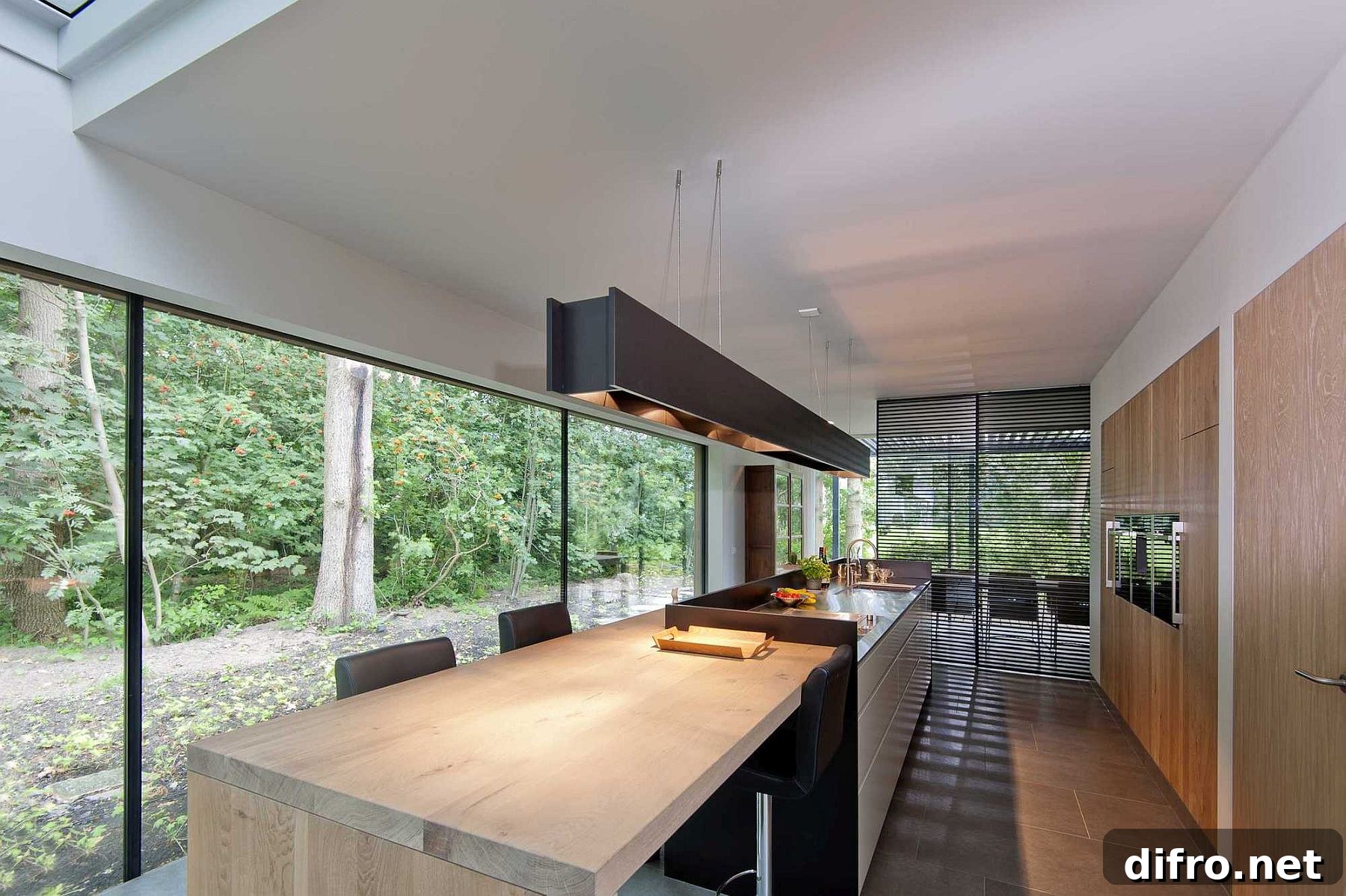 Black kitchen island with wooden breakfast nook and adjacent dining area