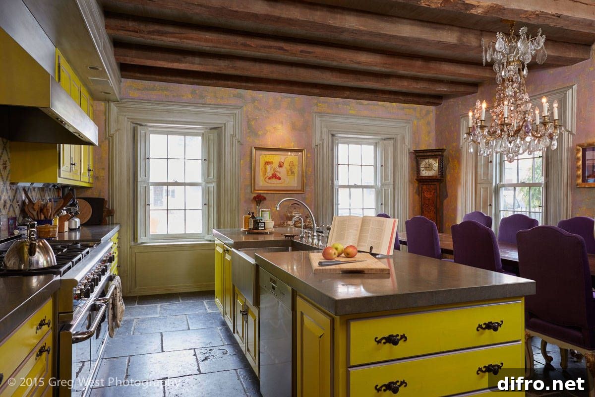 Yellow island and cabinets in a rustic kitchen