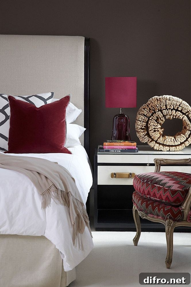 Dark red accents brighten a bedroom in white and deep gray