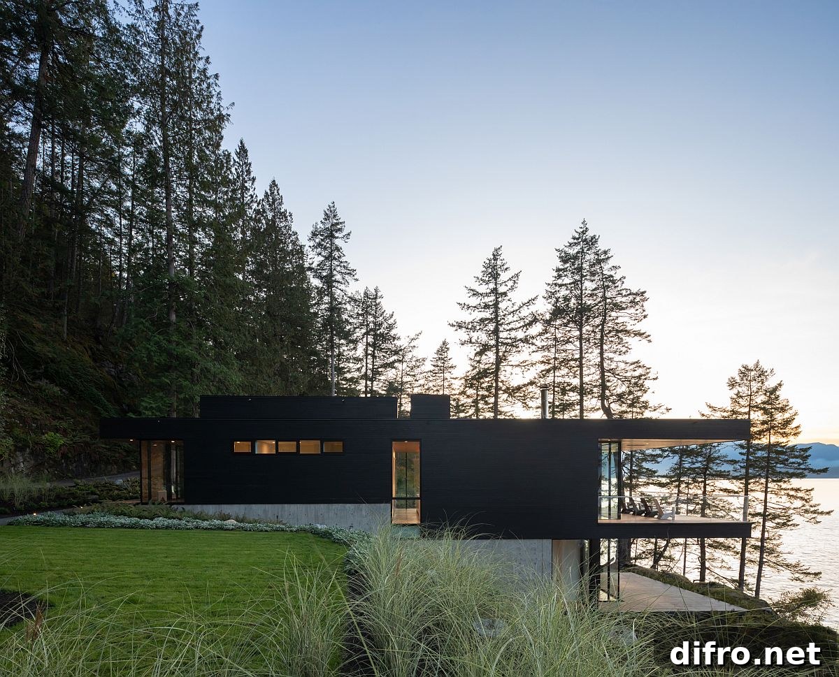 Black stained cedar exterior blending into forest at dusk