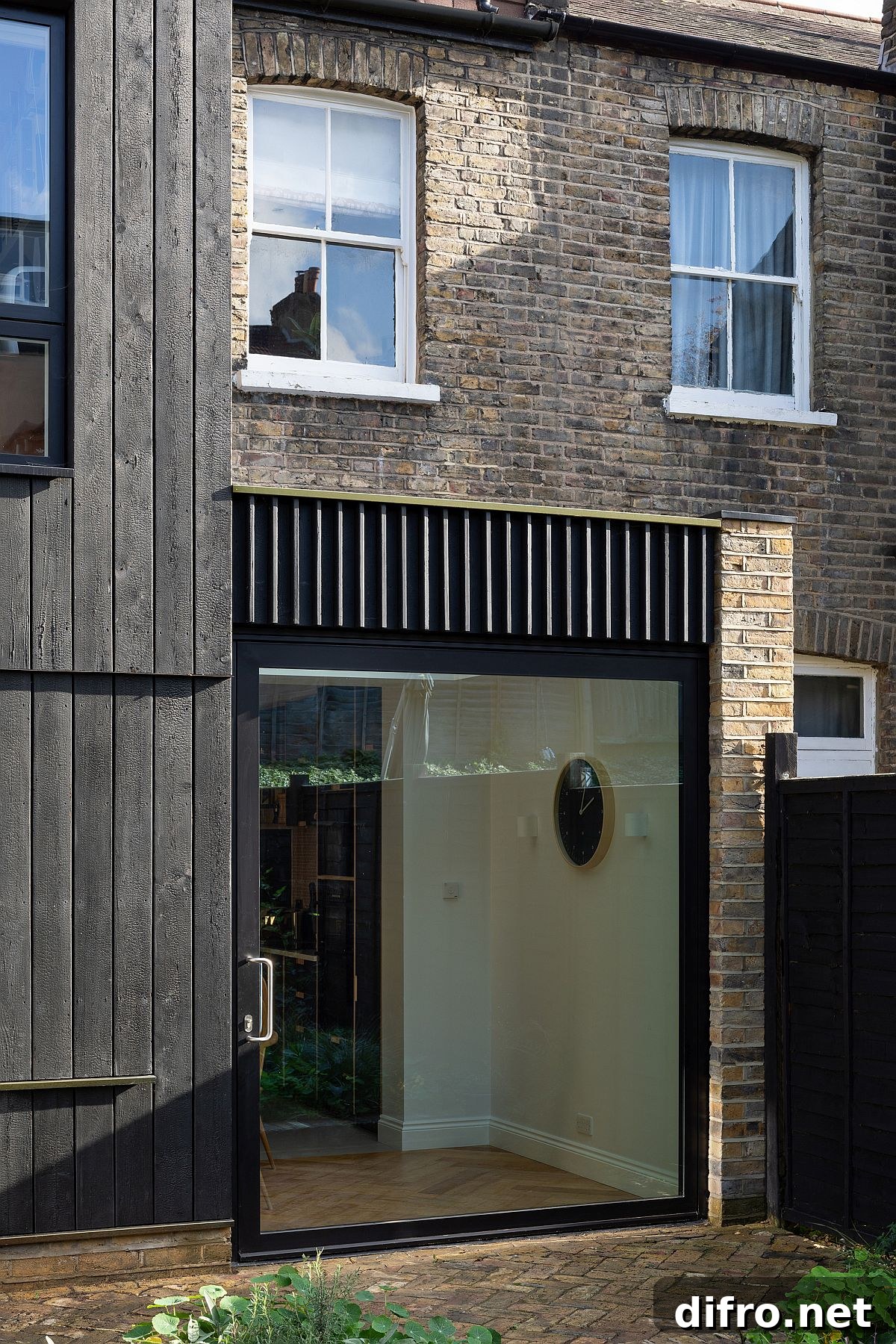 Charred timber next to brick wall
