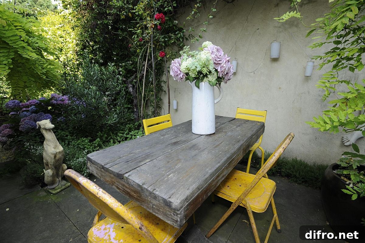Rustic wooden table with colorful chairs in shabby-chic patio