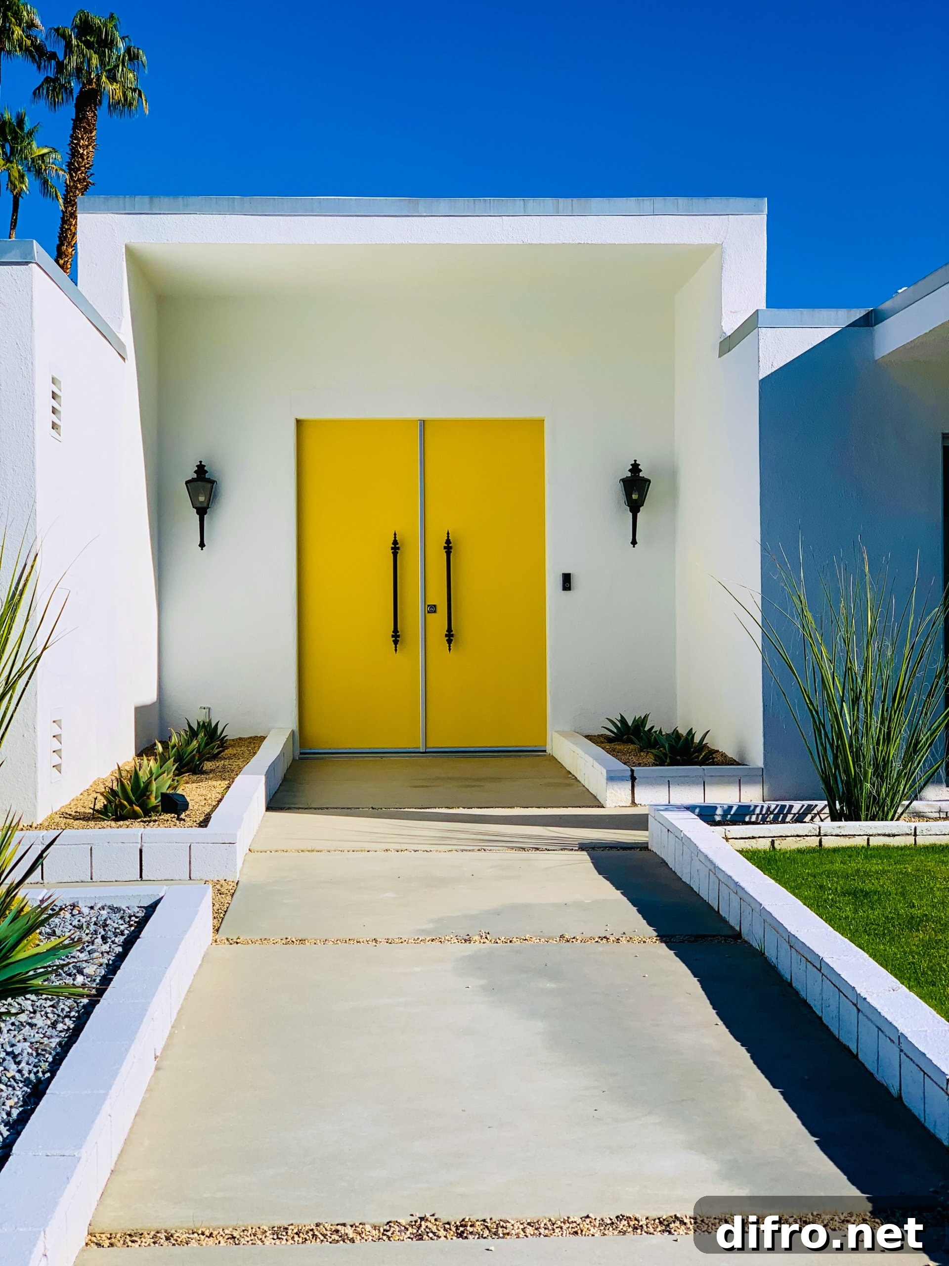 White wall with yellow door and black lamps