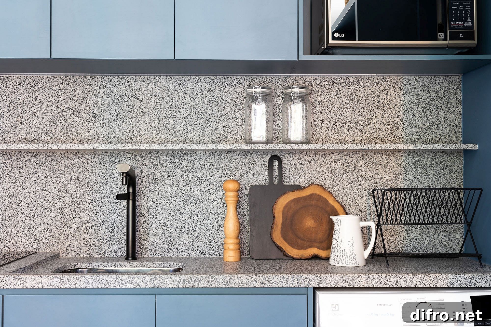 Closer look at the clean granite countertops and slim floating shelves in the blue contemporary kitchen