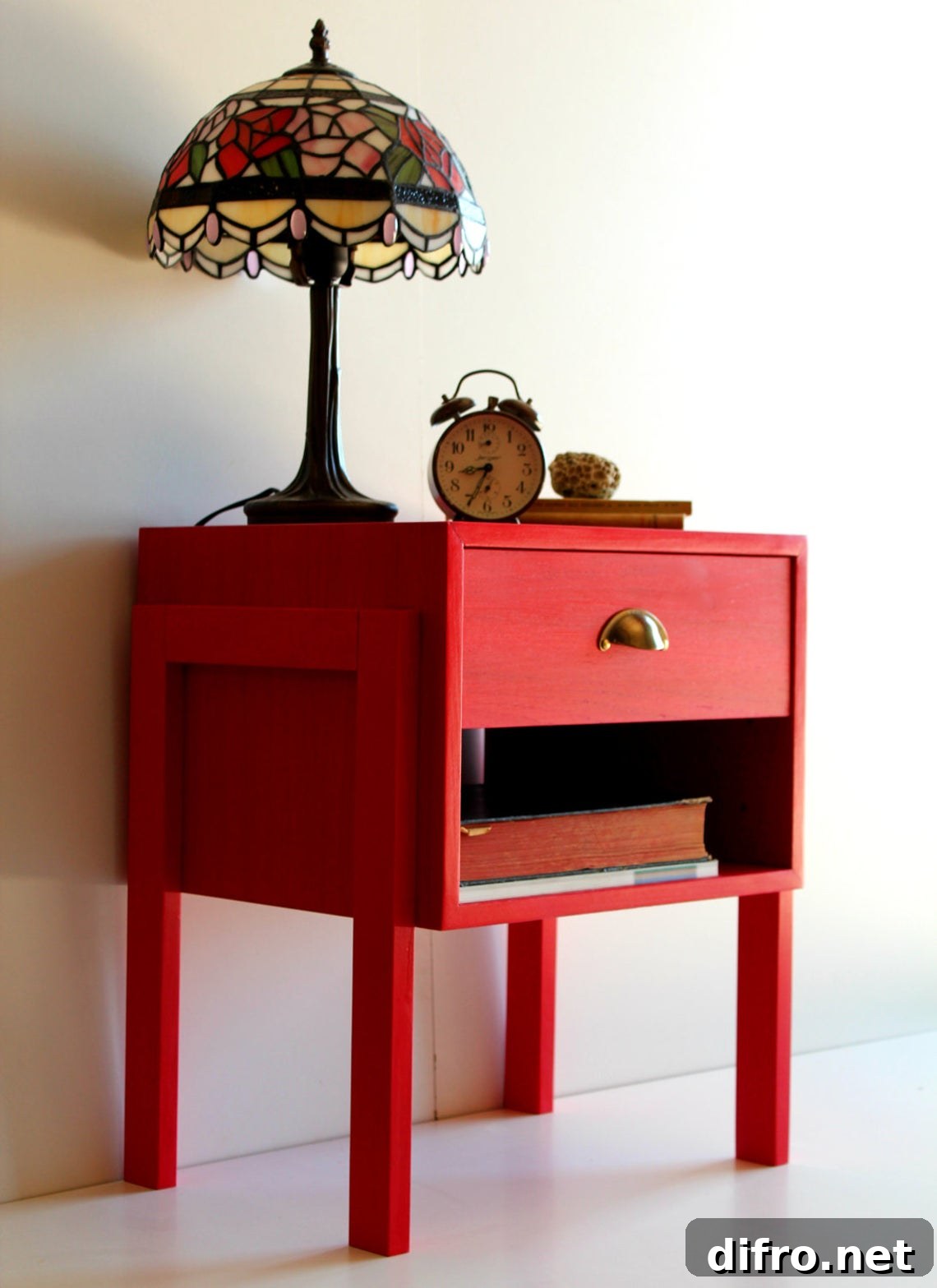 Lampshade and clock on top of a red drawer