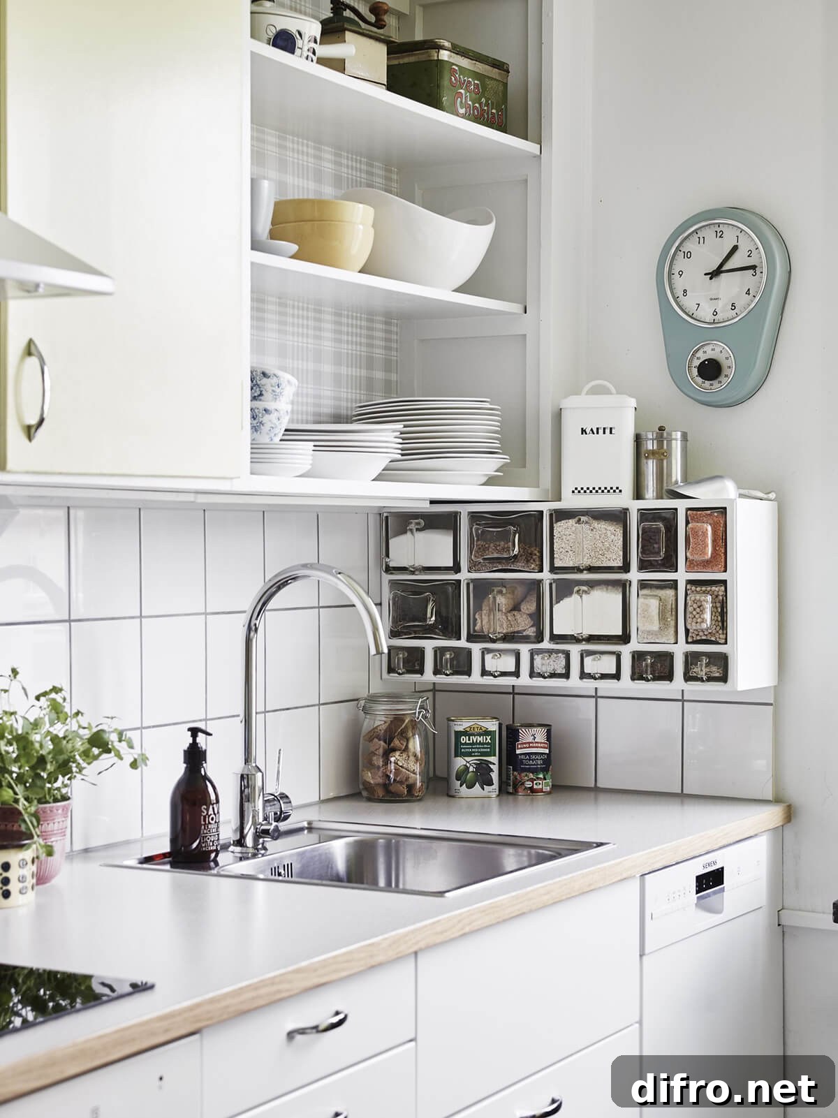 white kitchen with open shelving hanging storage boxes wall clock stainless steel sink