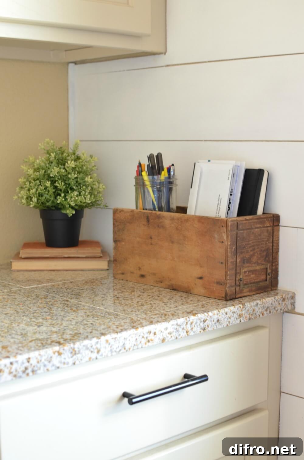 wooden vintage mail organizer on granite countertop with greenery in background