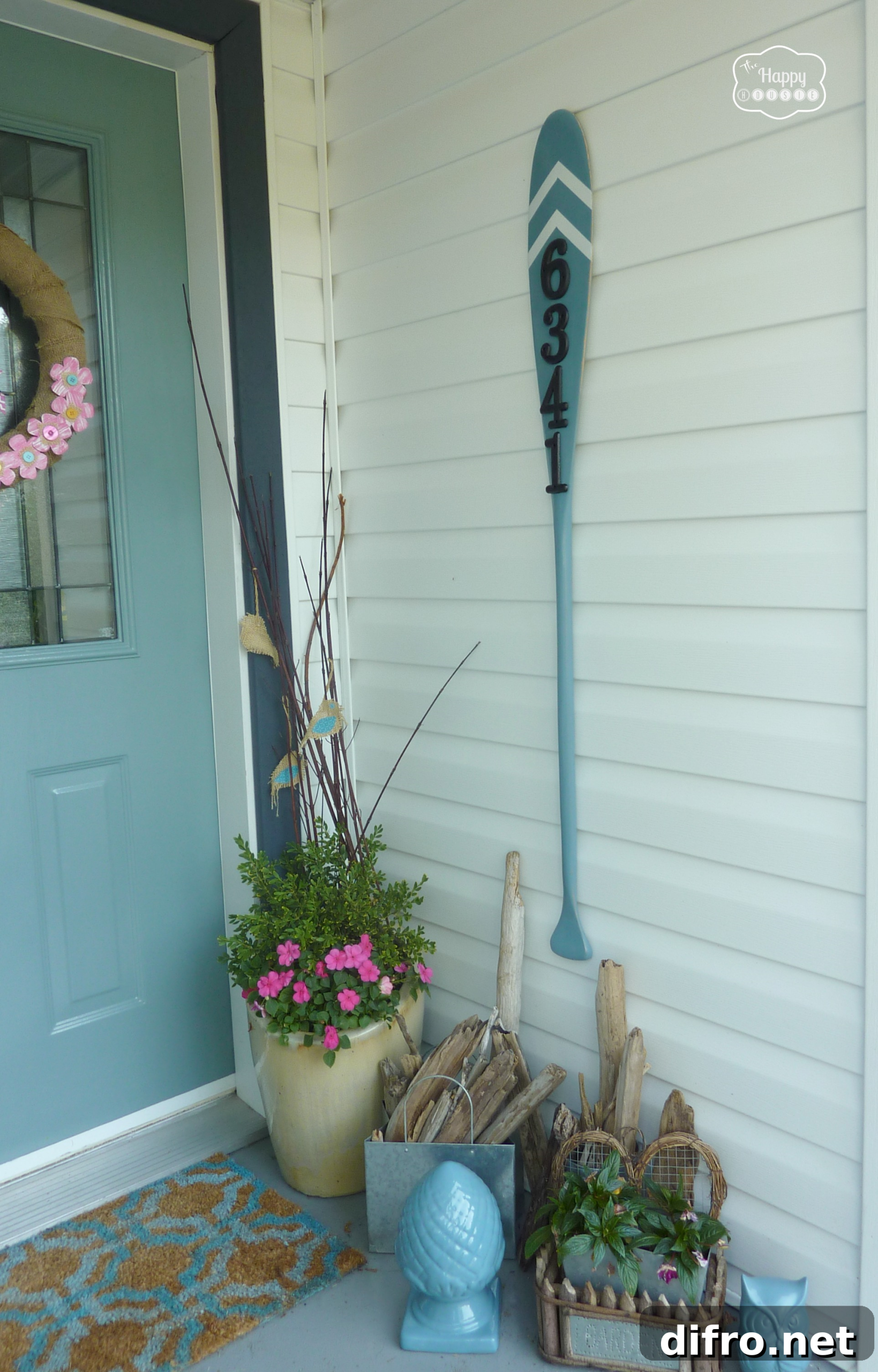 vintage paddle house number sign painted blue on white siding blue door and porch decor