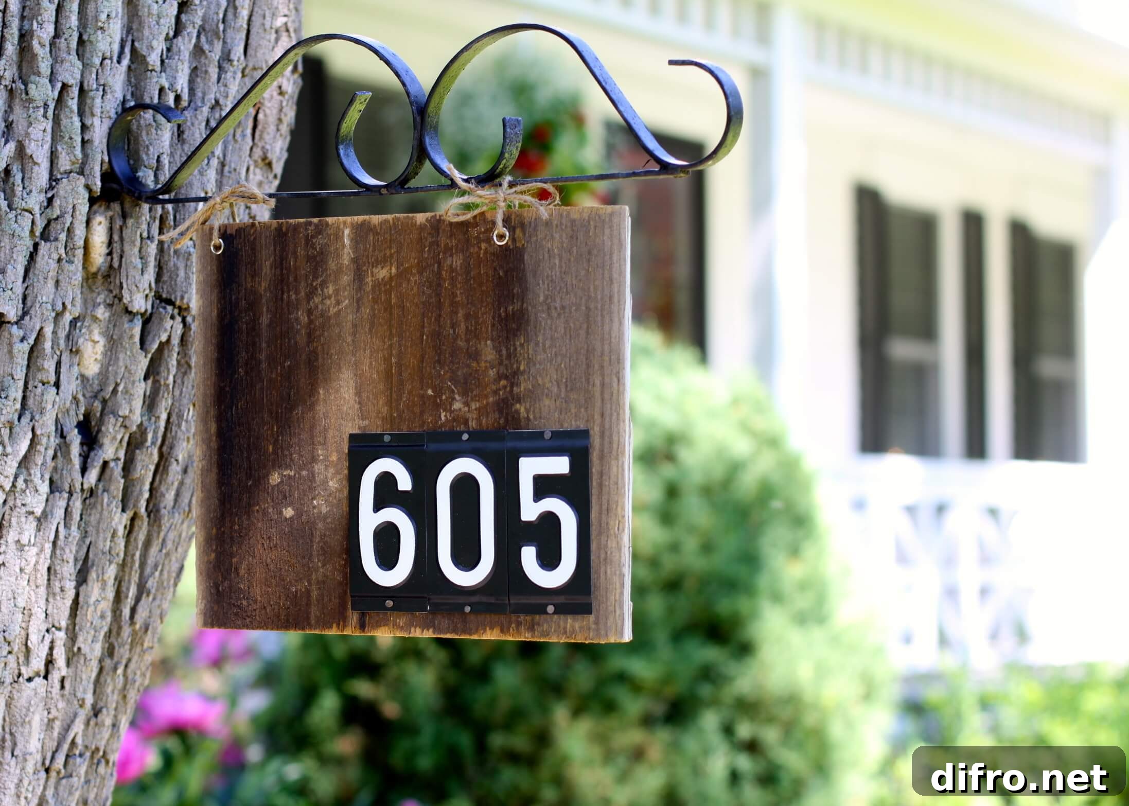 wood sign hanging from tree house numbers