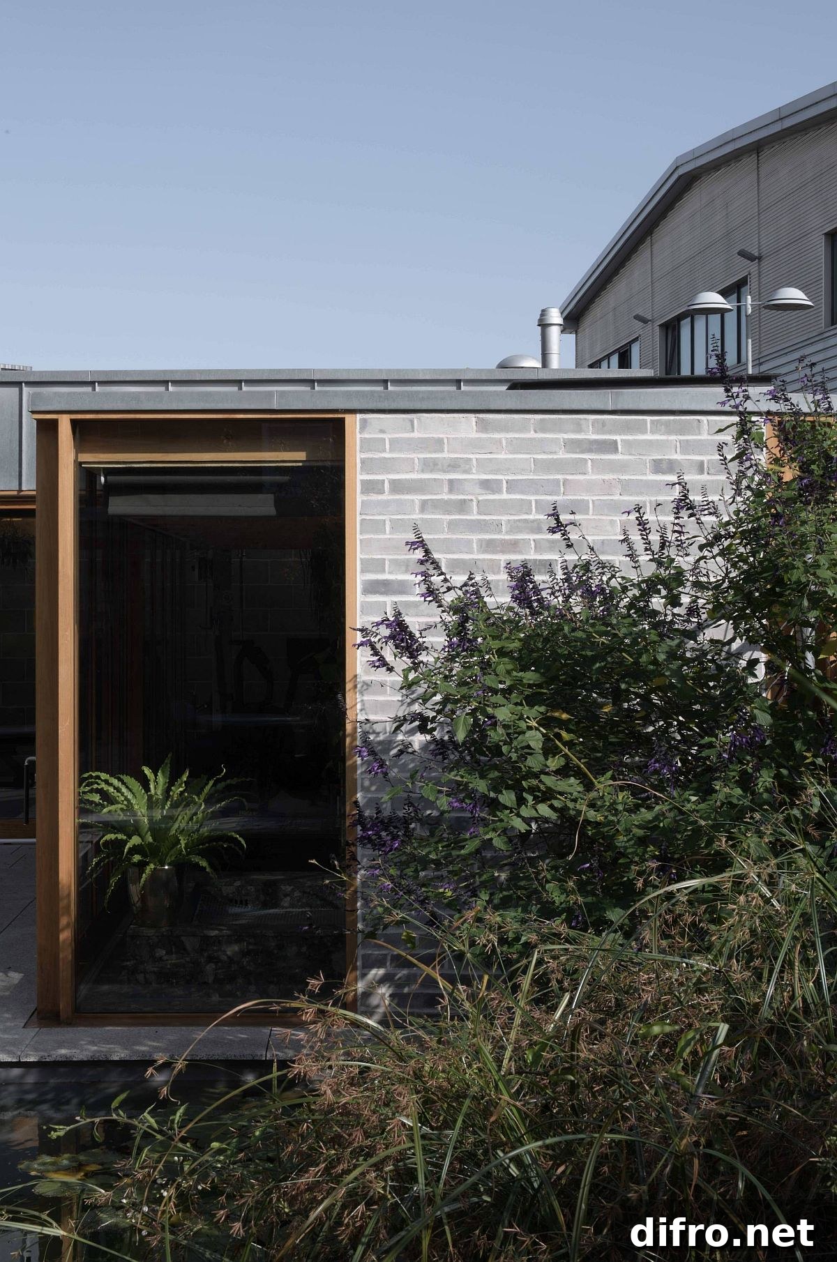 Exposed blockwork walls, wood and glass shape the lovely backyard escape