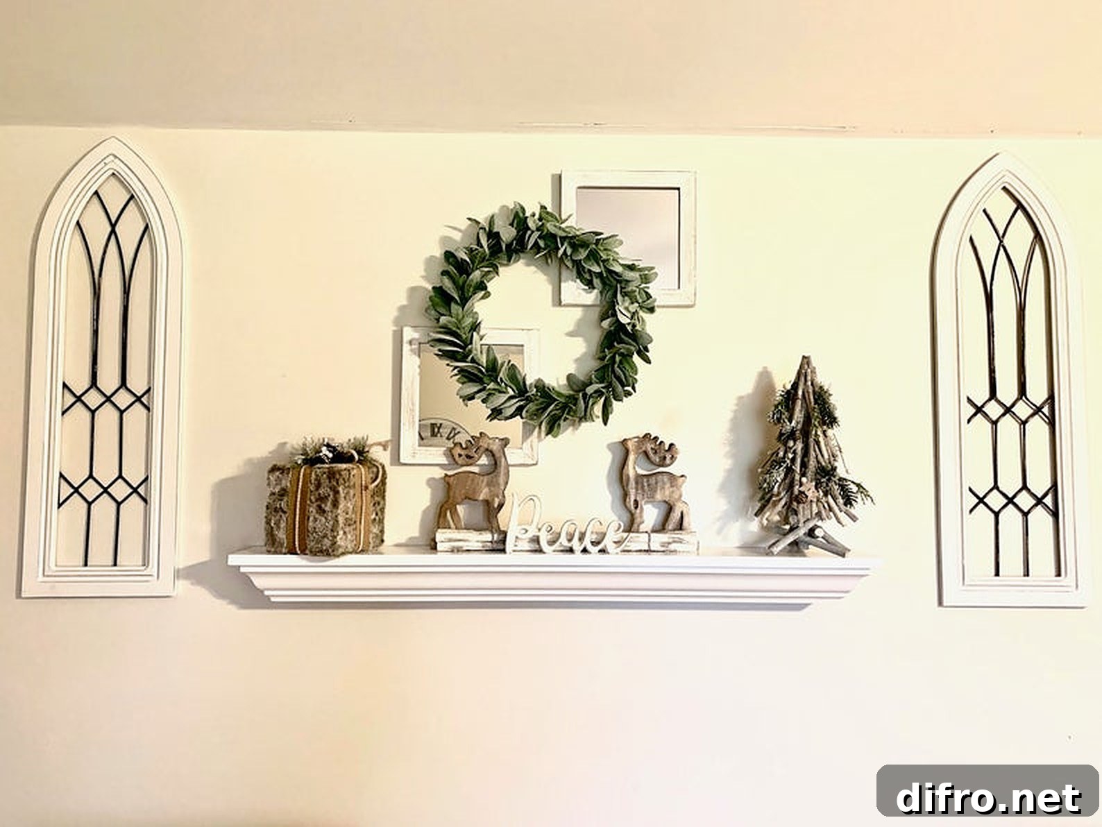 White floating mantel with green wreath and makeshift windows
