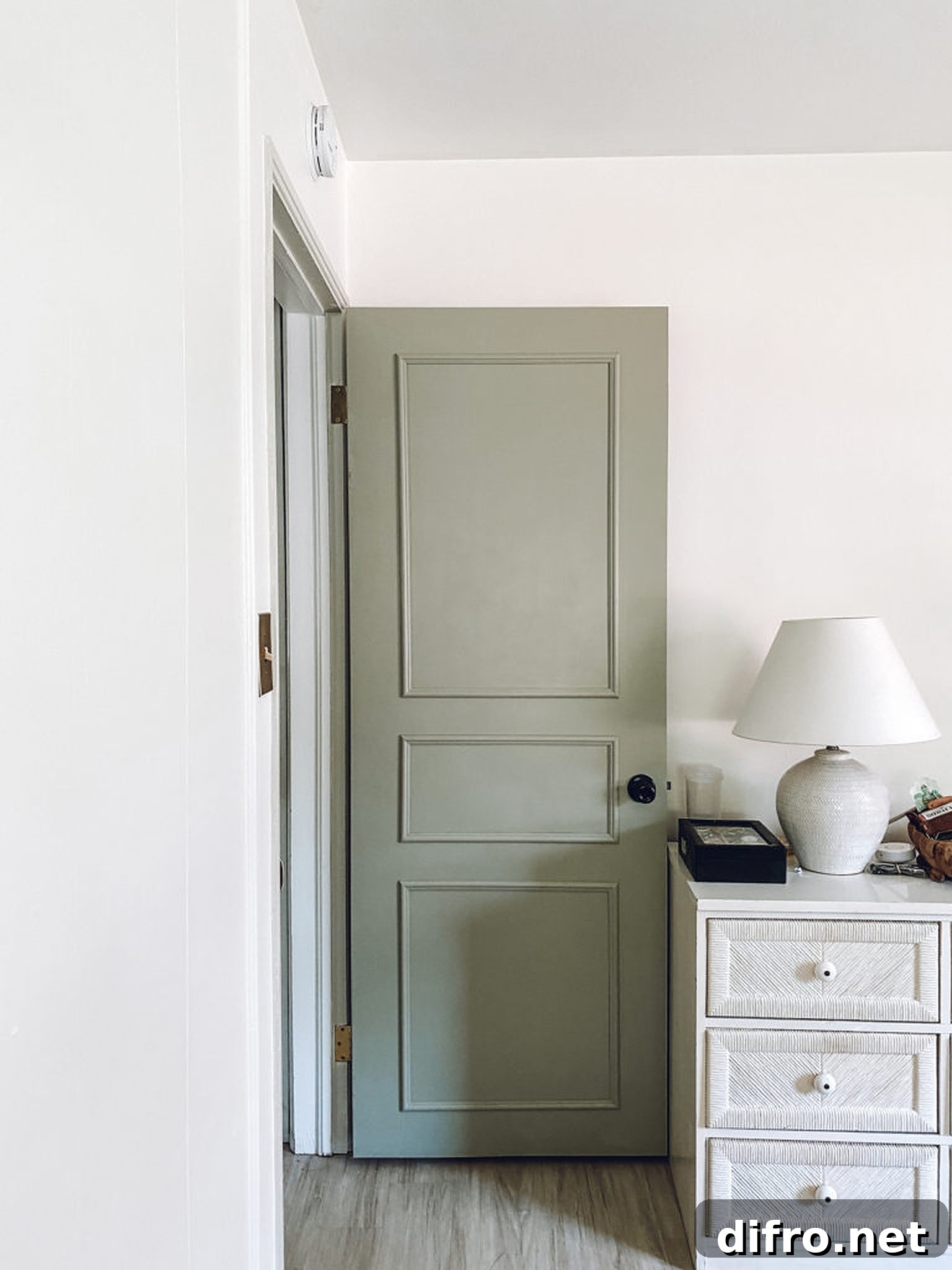 White lamp on white cabinet and an open door