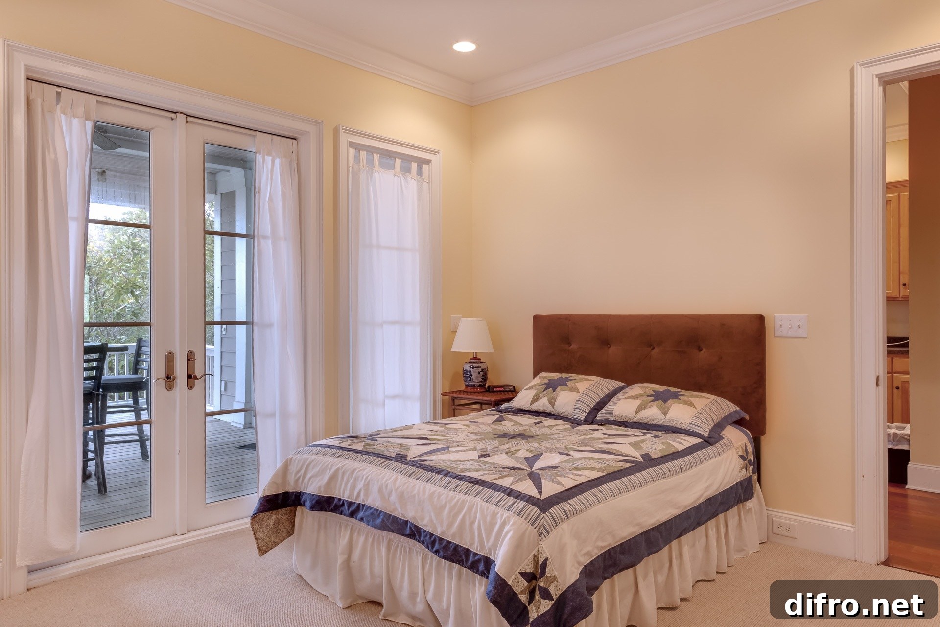 Beige bedroom with large bed and closed doors to the patio