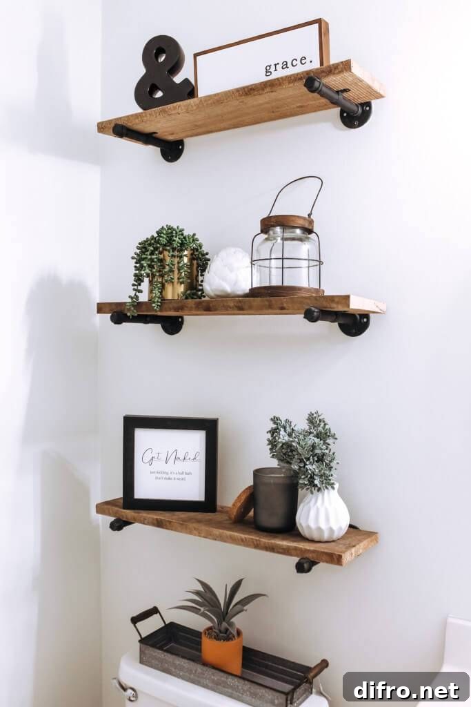 wood open shelving on wrought iron pipes decorated in farmhouse style over toilet