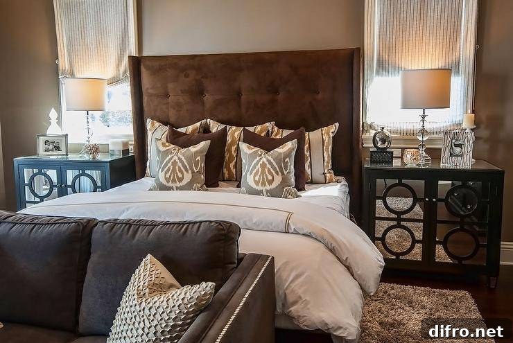 Warm brown velvet headboard with layered hotel bedding and leather sofa
