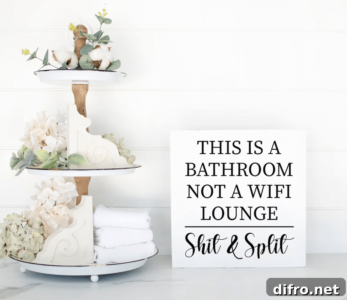 funny bathroom sign white next to tiered tray with greenery and decor