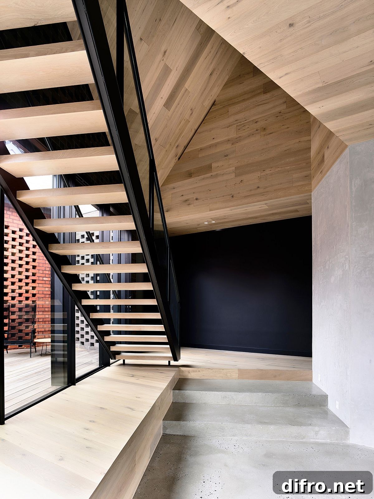 Glass walls bring natural light into the home with a new, sculptural staircase
