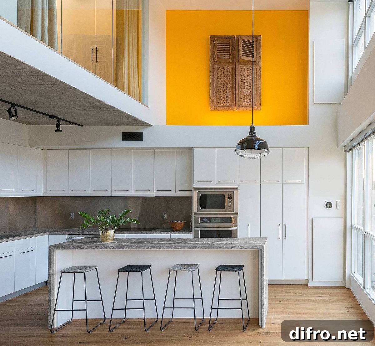 Modern double-height kitchen with stone countertops and white cabinets