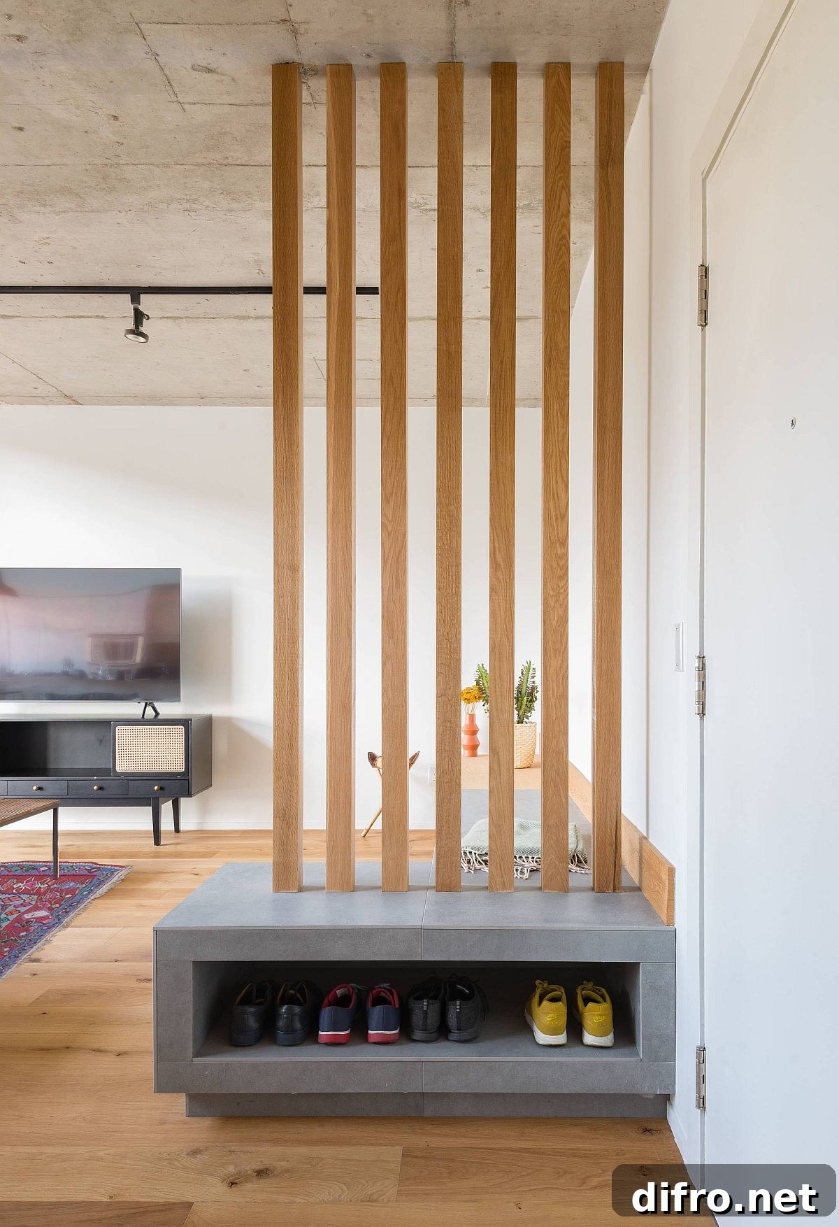 Wooden slats along with custom bench in the living room also offer shoe storage space for the entry