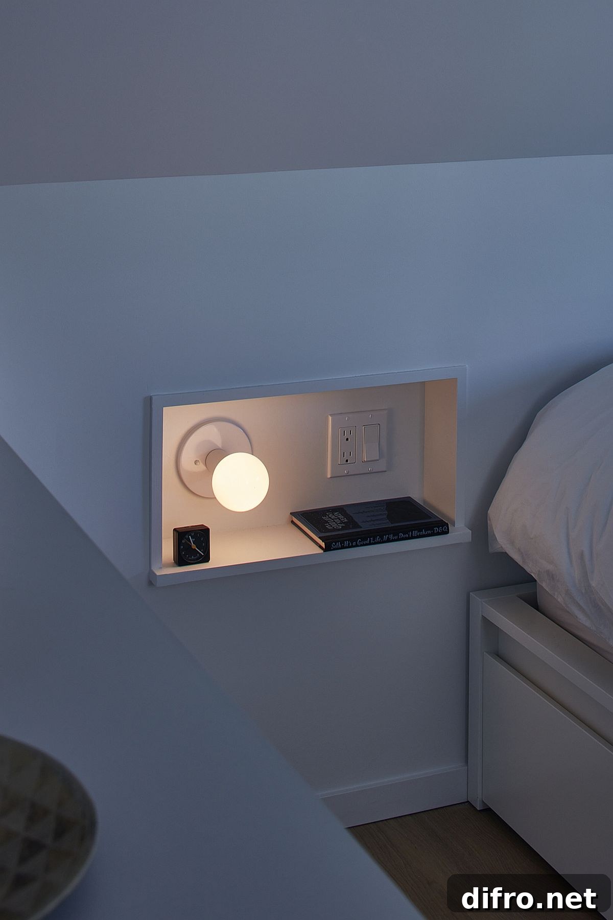 Small niche next to the bed inside the modern bedroom with space for a book and bed lamp