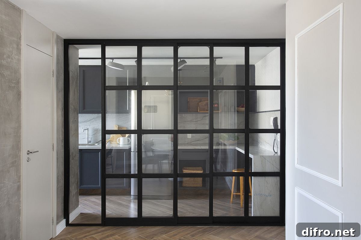 Dark-framed sliding glass doors separate the living area from the kitchen