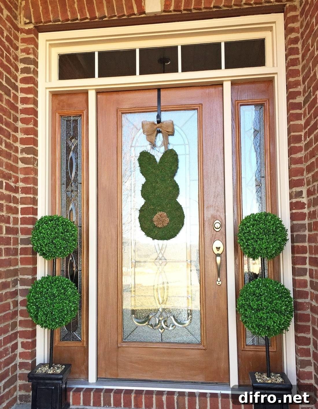 Moss bunny door decor with green potted plants on the sides