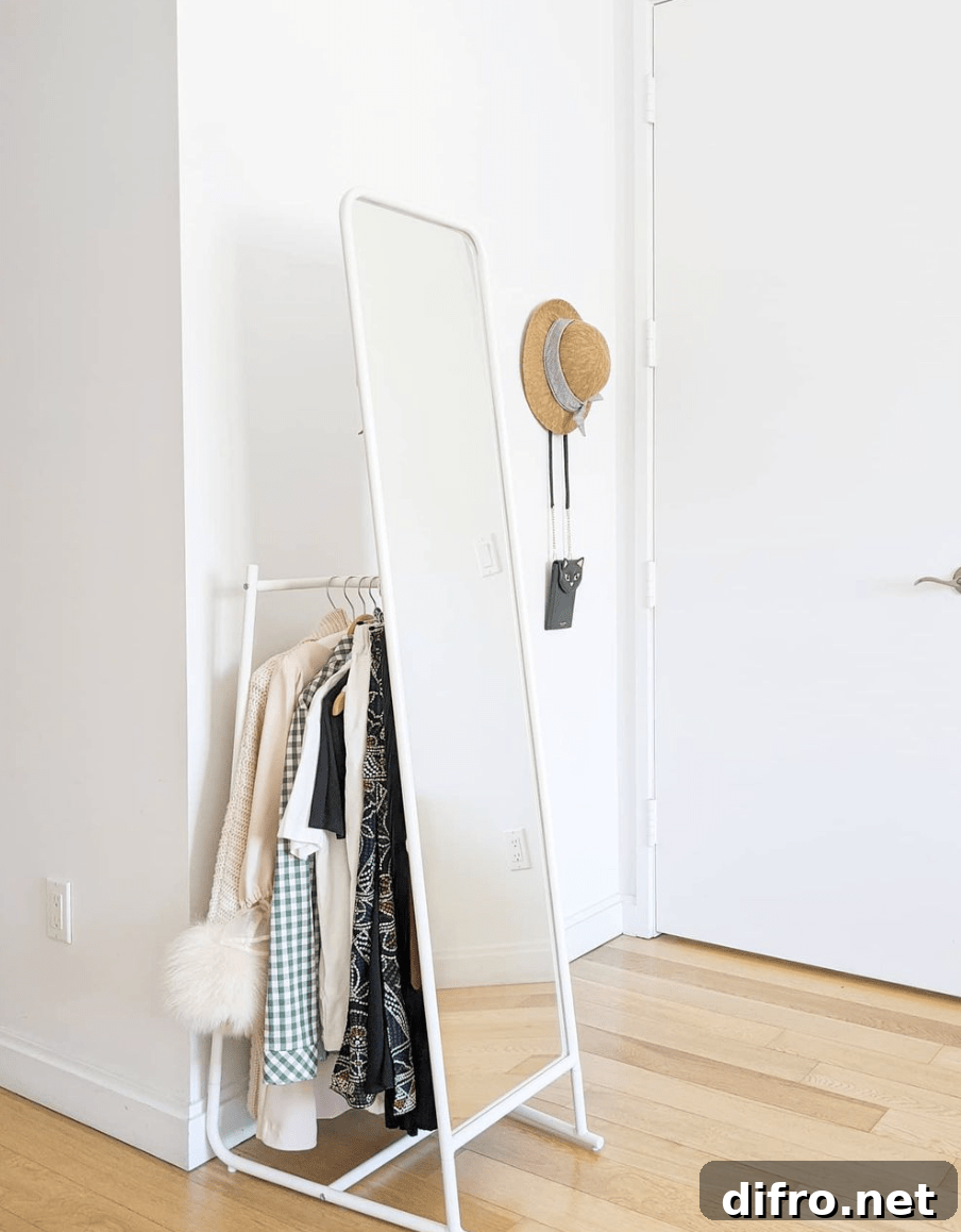 mirror clothing rack white with clothes behind it hat hanging on wall
