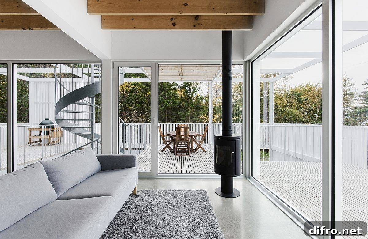 Lovely white living area of the house with glass walls and beautiful deck all around