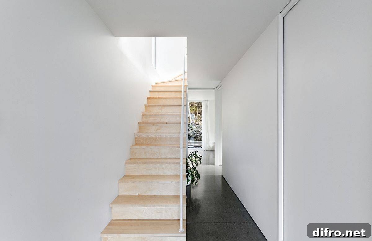 Wooden staircase brings warmth and elegance to the white interior of the home