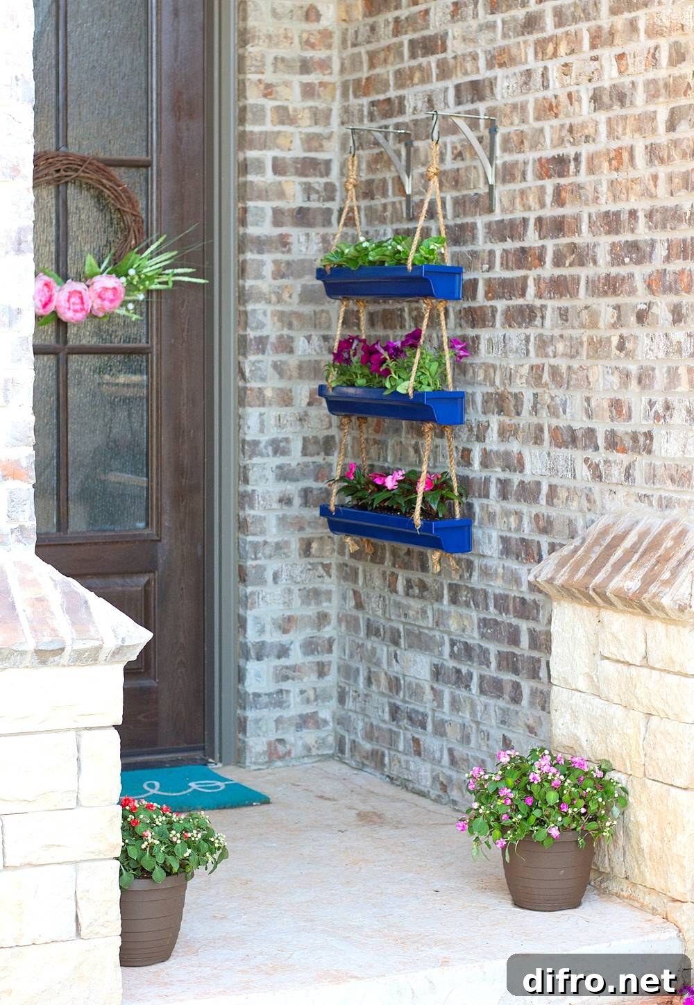 Blue hanging rain gutter planters on brick wall