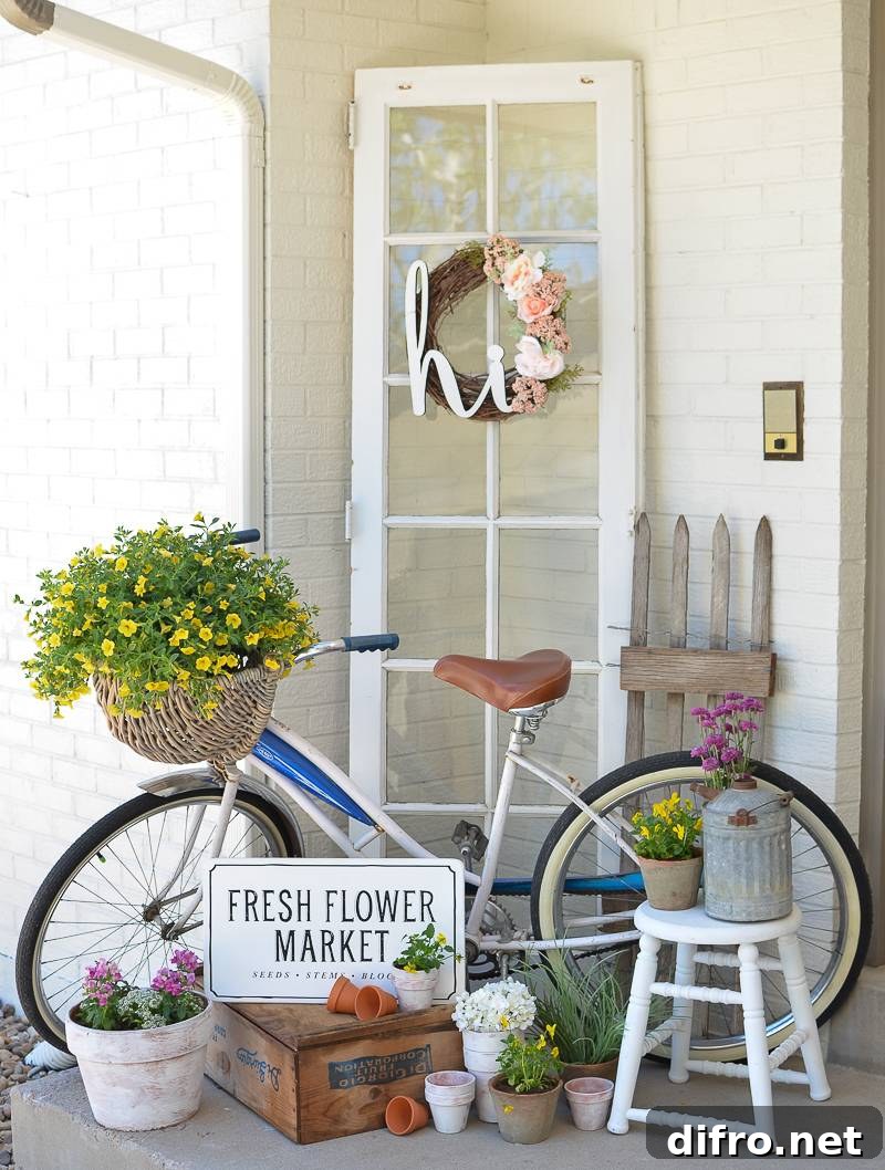 Bike with basket of yellow flowers leaning against white wall