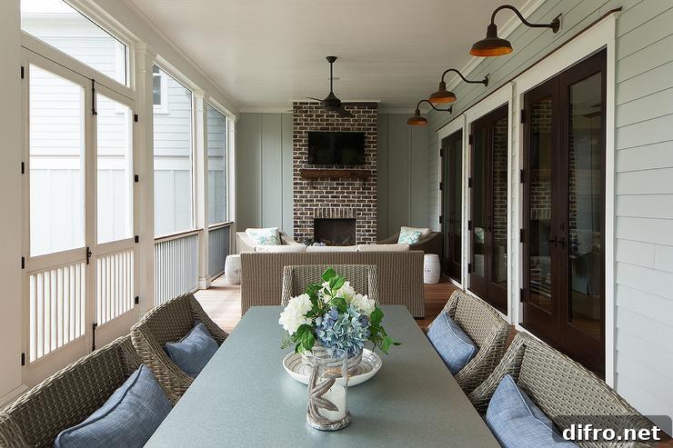 Enclosed back porch in a cottage home featuring a brick fireplace with a wood mantle and tv mounted overhead
