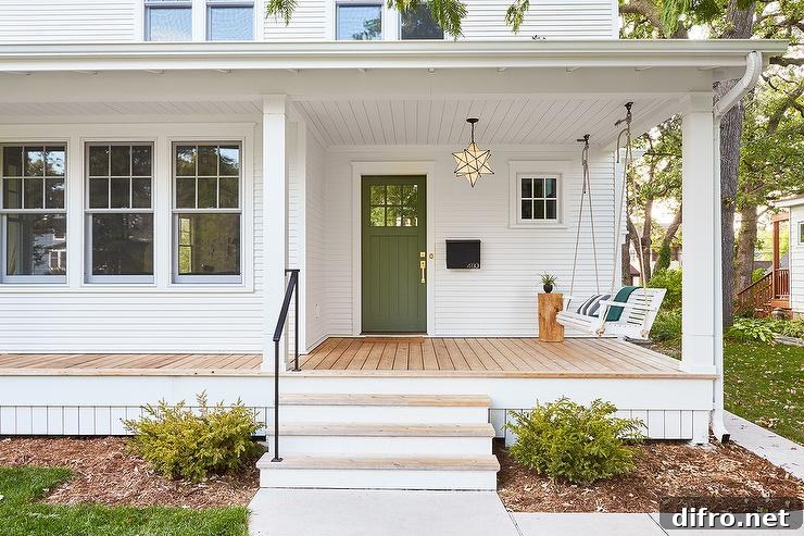simple white and wood front porch with green door and hanging swing star chandelier