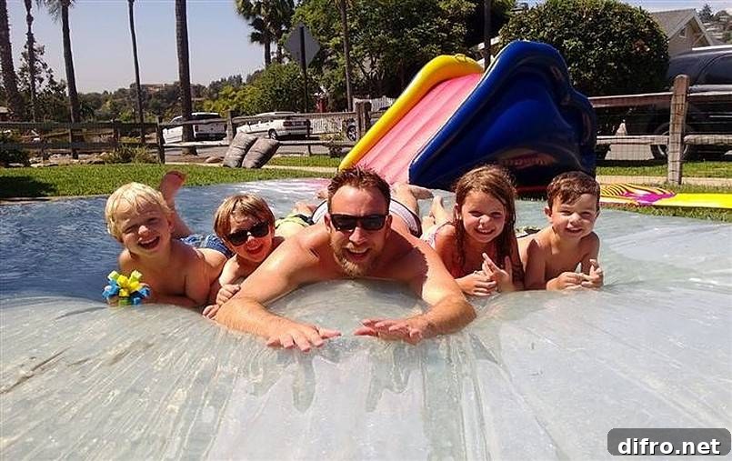 Man and kids on a water blob with small slide