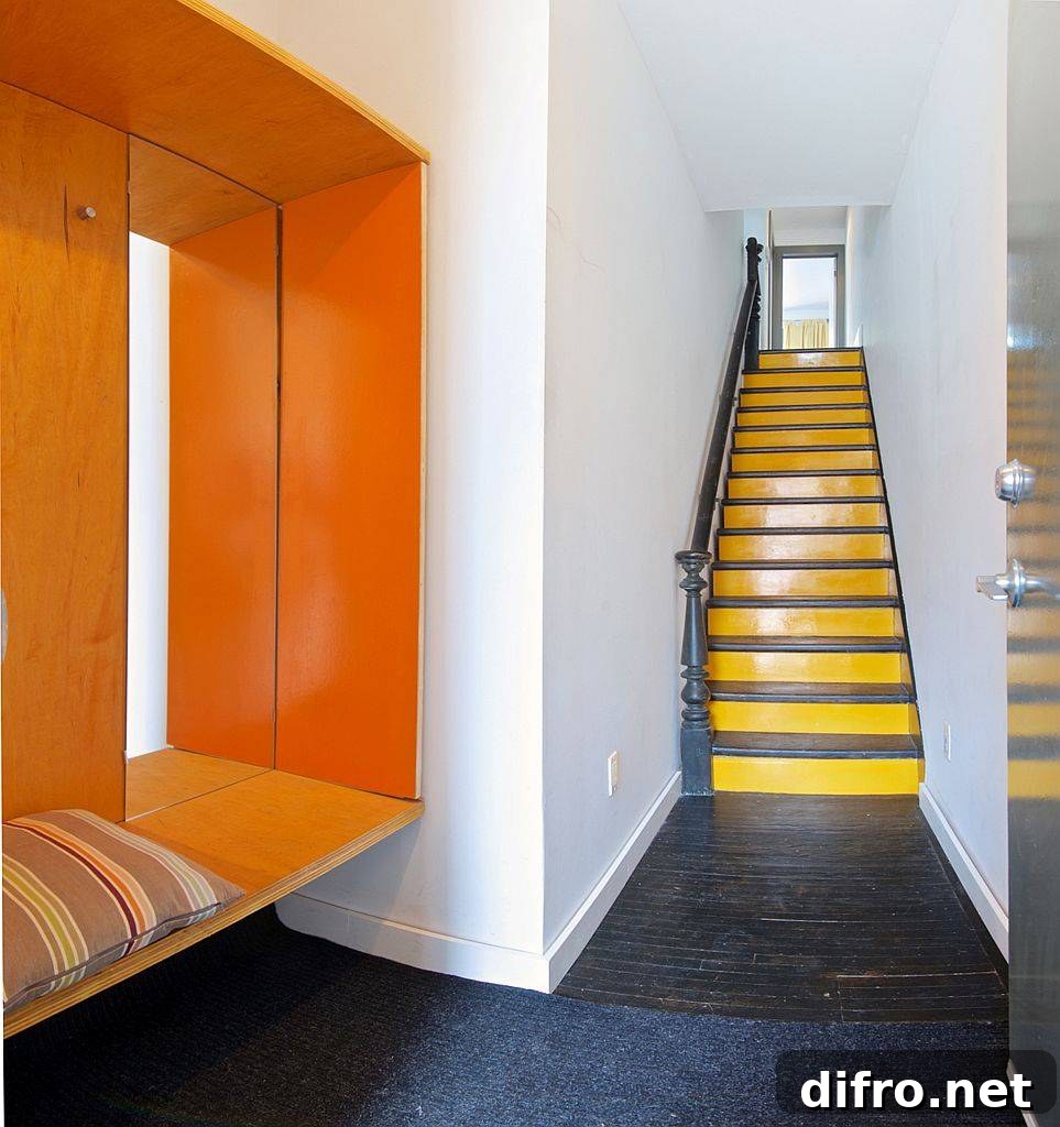 Modern entry with bench and a colorful splash of orange inside the Toronto home