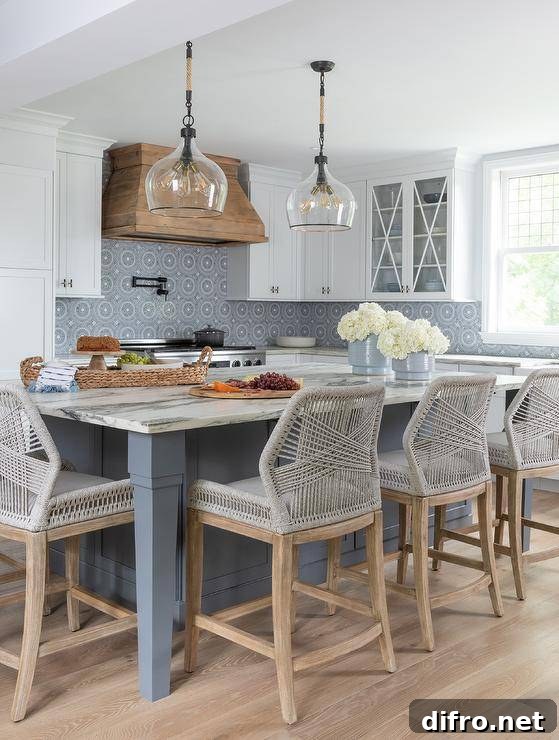 Blue kitchen island with marble countertop and lanterns.