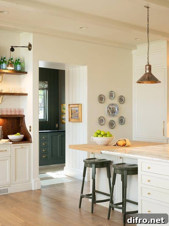 White center island with mixed wood and marble countertop and vintage lanterns.