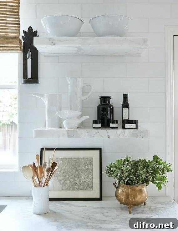 Marble floating shelves are stacked against white subway backsplash tiles and over a marble countertop.