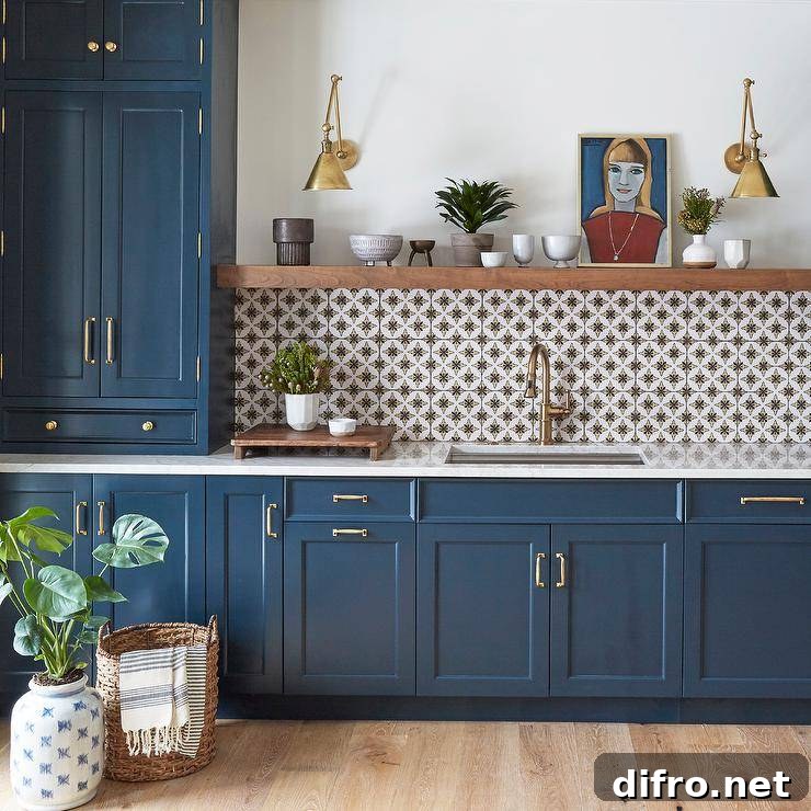 Blue cabinets paired with white and gray mosaic backsplash tiles and wood shelving.
