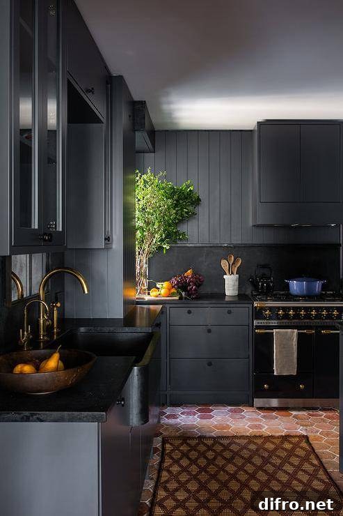 Black plank cabinets, black marble slab backsplash, and a black stove create a dramatic farmhouse kitchen.